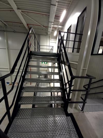 Zwart trappenhuis bedrijfshal met metalen treden